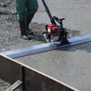 Listwa wibracyjna podczas wyrównywania świeżego betonu
Maszyna do poziomowania betonu na budowie
Listwa wibracyjna w trakcie pracy na wylewce betonowej